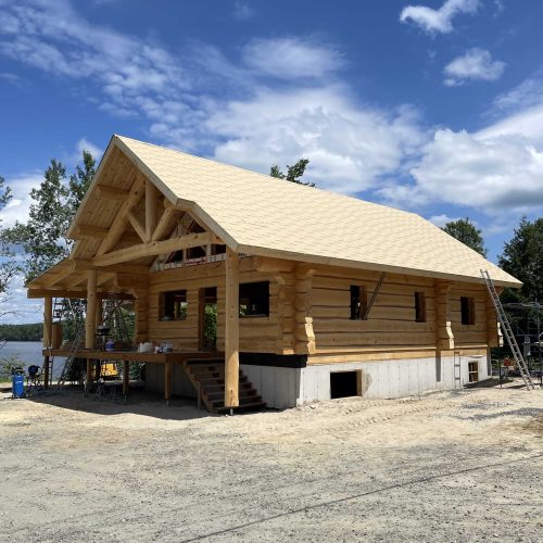 Installation kit de maison en bois rond et isolation toiture sandwich.